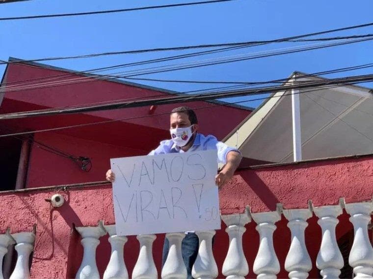 Com covid-19, Boulos aparece em sacada segurando cartaz: "Vamos virar"