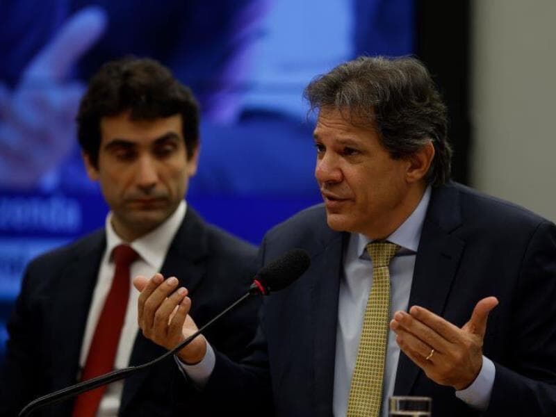 Fernando Haddad, falando, ao lado de Gabriel Galípolo. Ministro da Fazenda defendeu o presidente do BC após alta nos juros - Pedro Ladeira/Folhapress