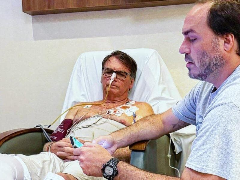 Jair Bolsonaro acompanhado do filho Carlos, na UTI. - Reprodução/Facebook (@jairmessias.bolsonaro)