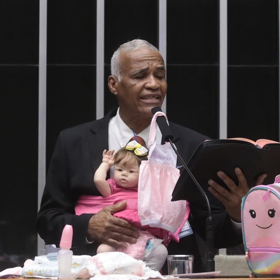 Pastor Sargento Isidório lê trecho da Bíblia, enquanto segura sua boneca "esborne". - Bruno Spada/Agência Câmara