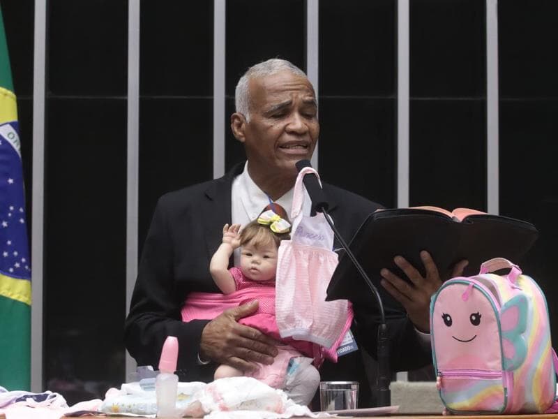 Pastor Sargento Isidório lê trecho da Bíblia, enquanto segura sua boneca "esborne". - Bruno Spada/Agência Câmara