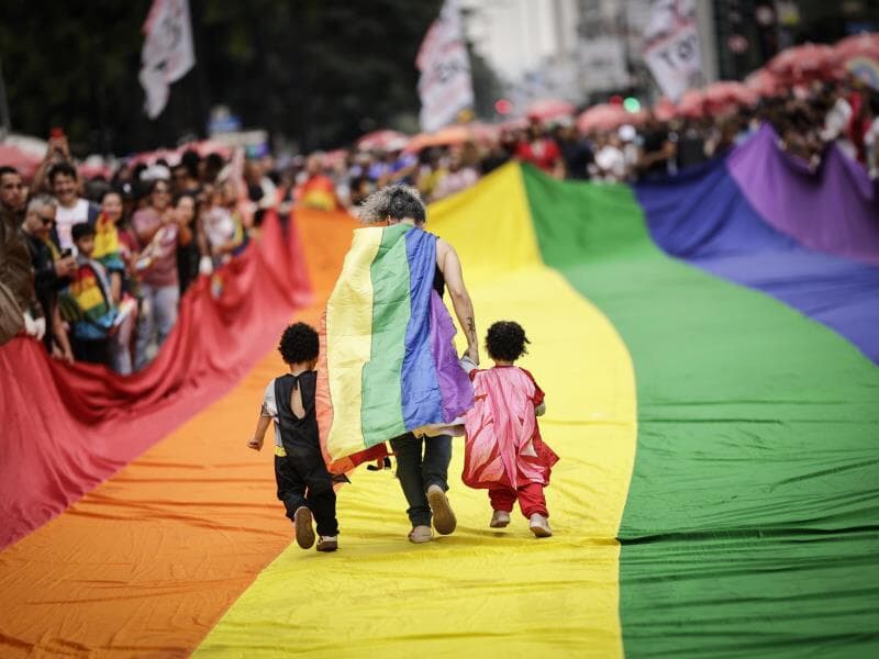 Participantes caminham sobre bandeira LGBTQIA+ durante a Parada Gay em São Paulo no último domingo. - Eduardo Knapp/Folhapress