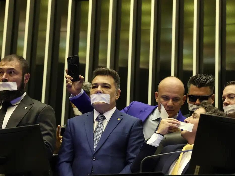 Com adesivo na boca, deputados bolsonaristas ocuparam a mesa da Câmara e por lá passaram toda a noite em protesto contra a prisão domiciliar do ex-presidente. - José Cruz/Agência Brasil