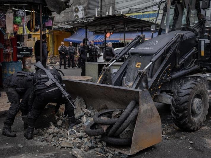  Policiais retiram barricada durante operação no Complexo da Maré, na zona norte do Rio de Janeiro. -  Eduardo Anizelli/Folhapress