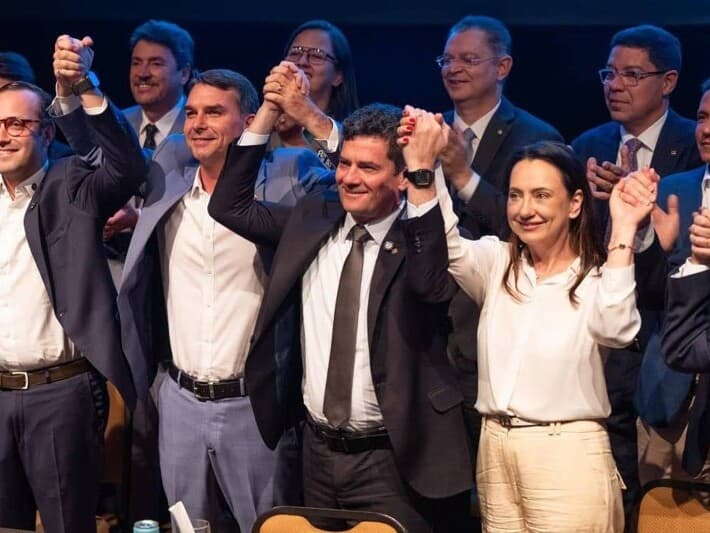 Sergio Moro segura a mão de Flávio Bolsonaro no ato de sua filiação ao PL nesta terça-feira em Brasília. - Claudio Gerber/Divulgação