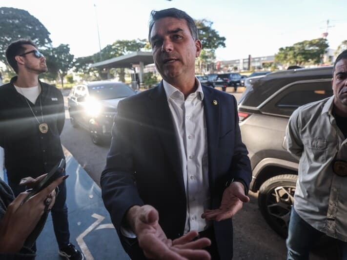 Flávio Bolsonaro fala com jornalistas durante entrevista coletiva em frente ao aeroporto de Brasília na última sexta-feira (15). - Gabriela Biló/Folhapress