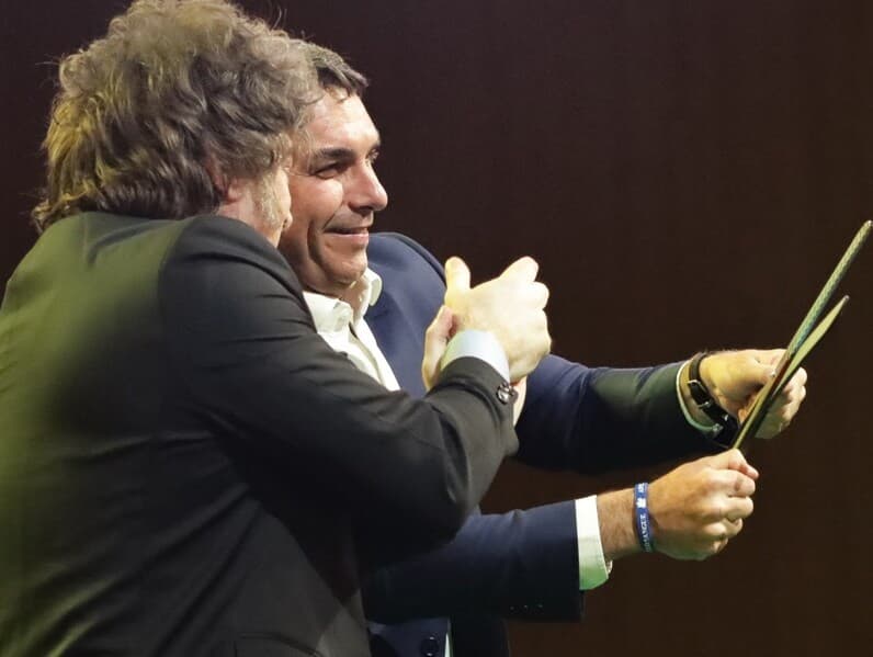Flávio segura uma tesoura ao lado do presidente argentino, Javier Milei, seu aliado, em 25 de julho de 2026.  -  Gabriel Silva/RasPress/Folhapress