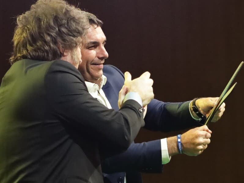 Flávio segura uma tesoura ao lado do presidente argentino, Javier Milei, seu aliado, em 25 de julho de 2026. - Gabriel Silva/RasPress/Folhapress Flávio segura uma tesoura ao lado do presidente argentino, Javier Milei, seu aliado, em 25 de julho de 2026. - Gabriel Silva/RasPress/Folhapress